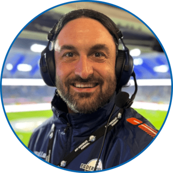 Porträt von Reporter Sebastian Schulz in der Home Deluxe Arena. Er trägt seine langen dunklen Haare offen, einen Vollbart sowie ein SCP07-Schlüsselband über seiner dunkelblauen Winterjacke.