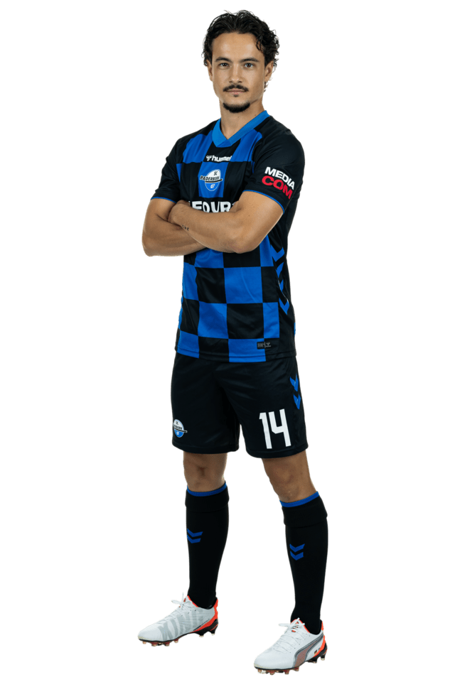 Mika Baur steht leicht nach links eingedreht mit verschränkten Armen. Er trägt das aktuelle Heimtrikot.