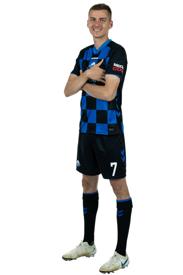 Filip Bilbija steht leicht nach links eingedreht mit verschränkten Armen. Er trägt das aktuelle Heimtrikot.