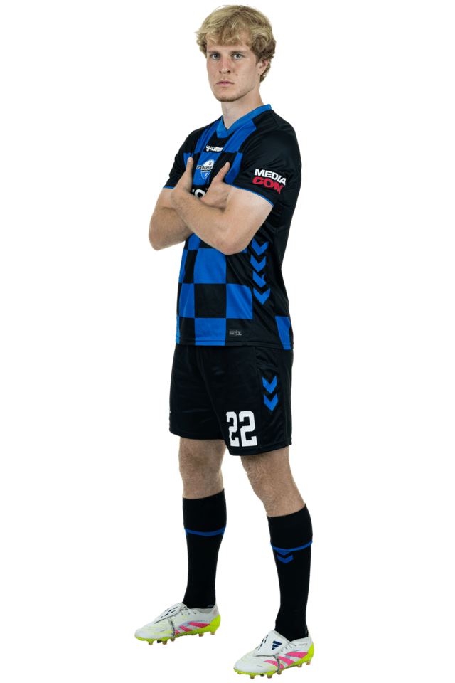 Mattes Hansen steht leicht nach links eingedreht mit verschränkten Armen. Er trägt das aktuelle Heimtrikot.