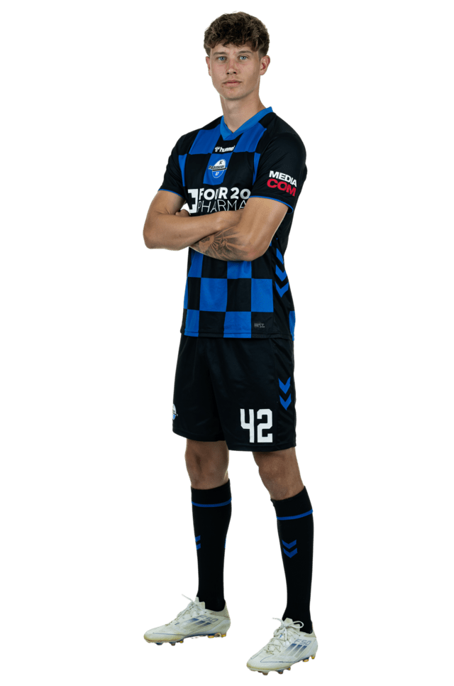 Kevin Krumme steht leicht nach links eingedreht mit verschränkten Armen. Er trägt das aktuelle Heimtrikot.