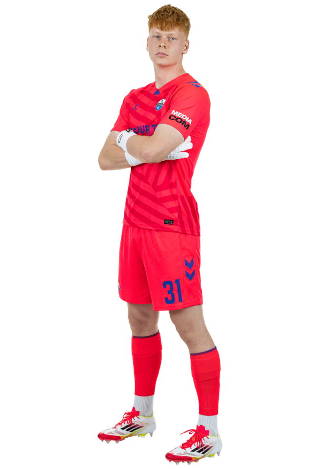 Florian Pruhs steht leicht nach links eingedreht mit verschränkten Armen. Er trägt das aktuelle pinke Torwarttrikot.